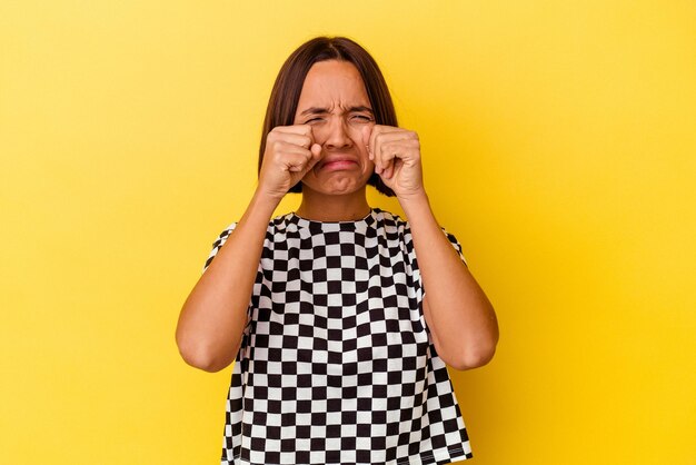 Young mixed race woman isolated on yellow background whining and crying disconsolately.