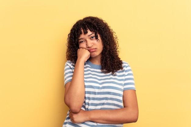 Photo young mixed race woman isolated on yellow background who feels sad and pensive looking at copy space