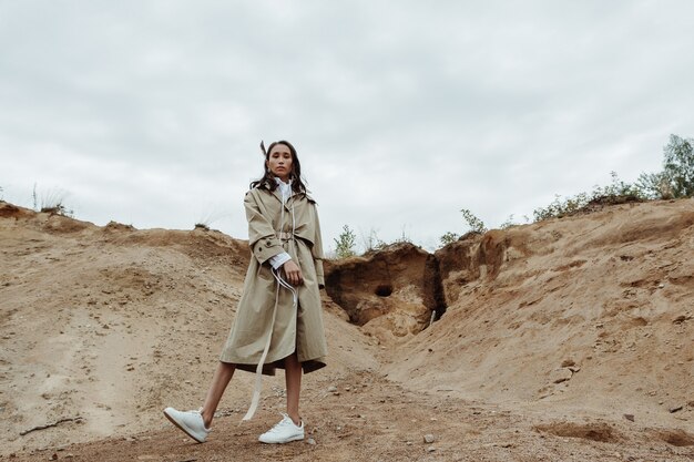 Young mixed race woman-traveller posing in the deserted landscape.