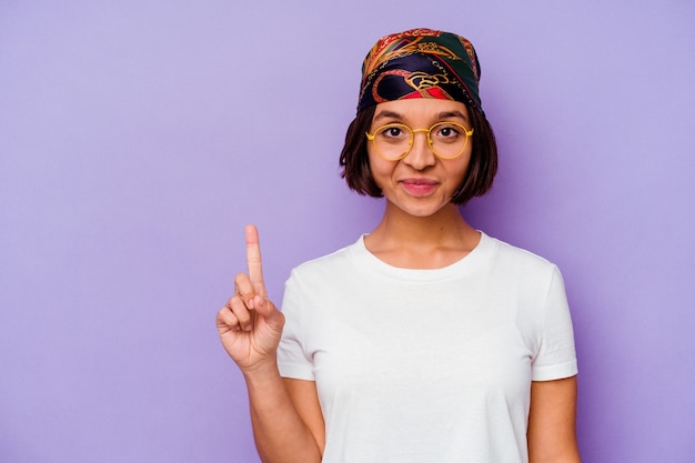 Young mixed race woman wearing a bandana isolated on purple background showing number one with finger.