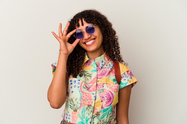 Young mixed race woman wearing sunglasses taking a vacation isolated excited keeping ok gesture on eye.