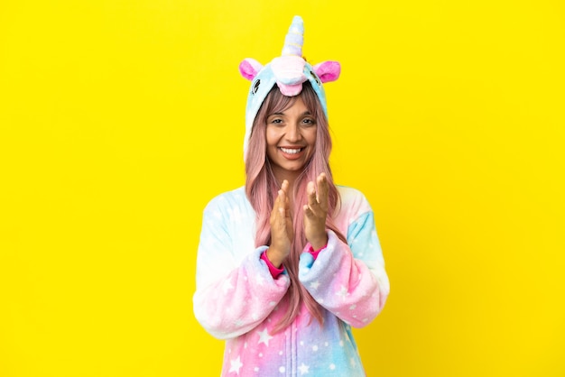 Young mixed race woman wearing a unicorn pajama isolated on white background applauding after presentation in a conference