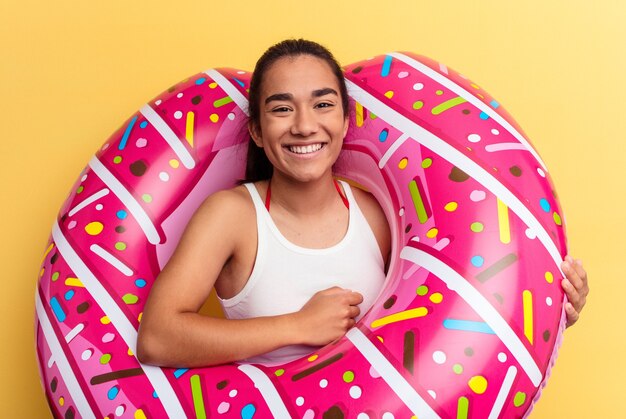 Young mixed race woman with air mattress laughing and having fun.