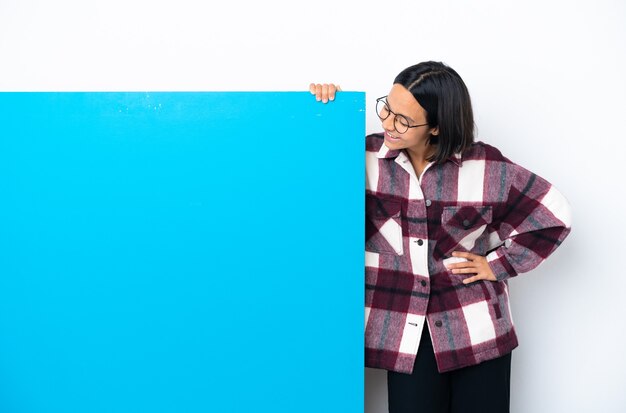 Young mixed race woman with a big blue placard isolated on white background thinking an idea while looking up