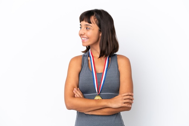 Young mixed race woman with medals isolated on white background looking side