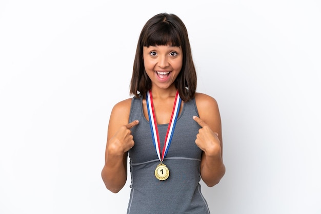 Young mixed race woman with medals isolated on white background with surprise facial expression