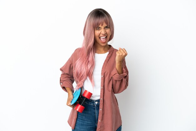 Young mixed race woman with pink hair isolated on white background with a skate