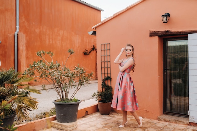 A young model girl in a beautiful dress in the countryside in France. Girl in the spring Provence village.