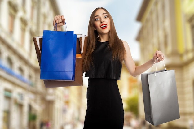 Young model outdoors carrying her shopping bags