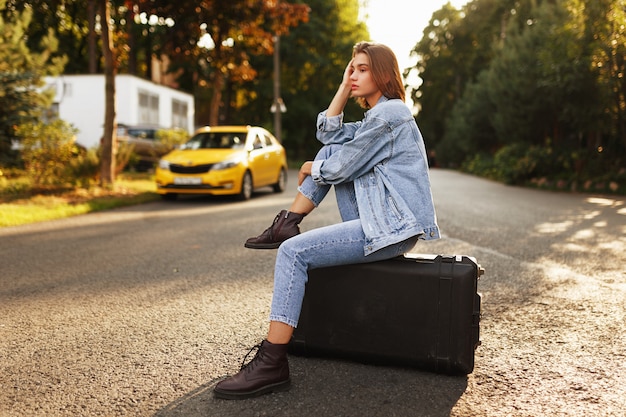 Young model posing on a suitcase