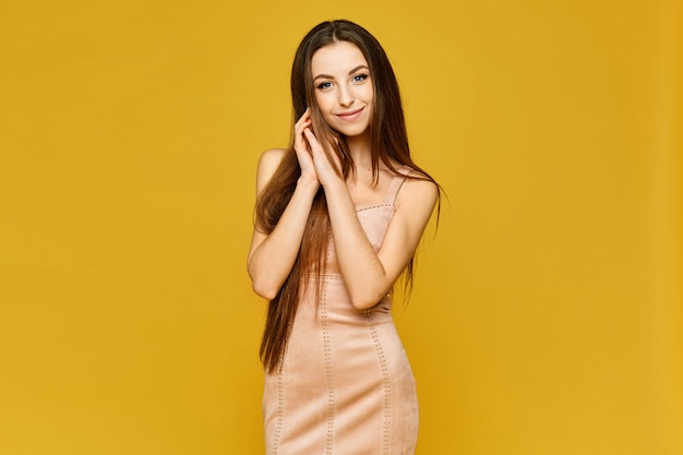 Young model woman in a short beige dress