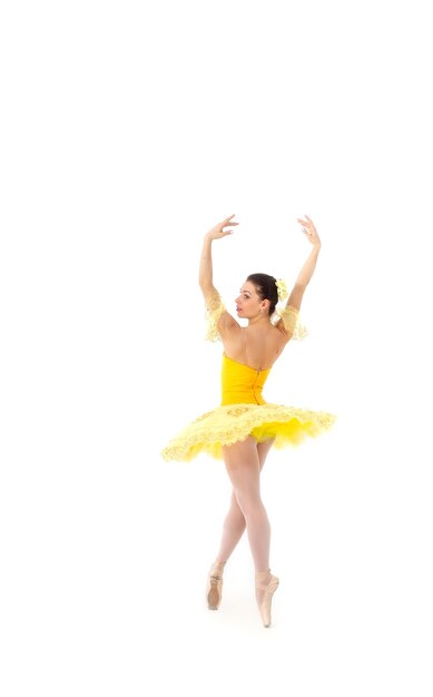 Young modern ballerina with yellow tutu doing the pose.