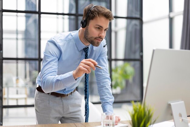 Young modern business man analyzing data using computer while working in the office