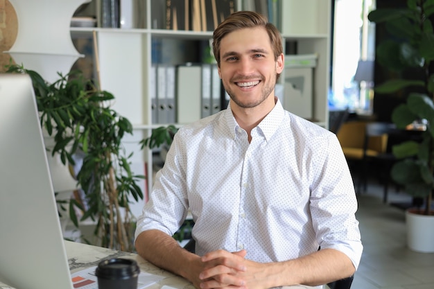 Young modern business man working using computer while sitting in the office.