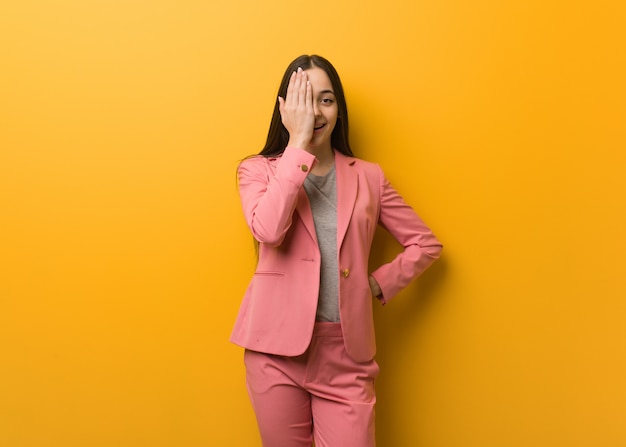 Young modern business woman shouting happy and covering face with hand