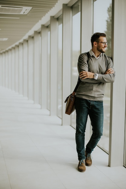 Young modern businessman standing in the office corridor