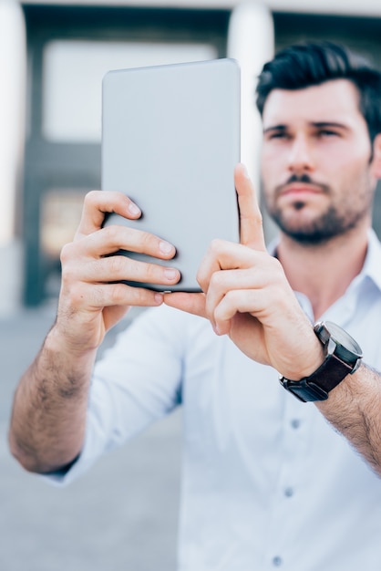 Young modern businessman using tablet