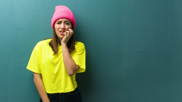 Young modern woman biting nails, nervous and very anxious