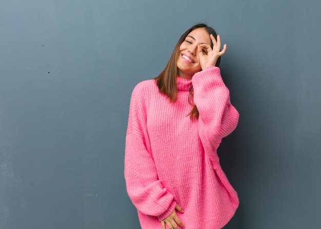 Young modern woman confident doing ok gesture on eye