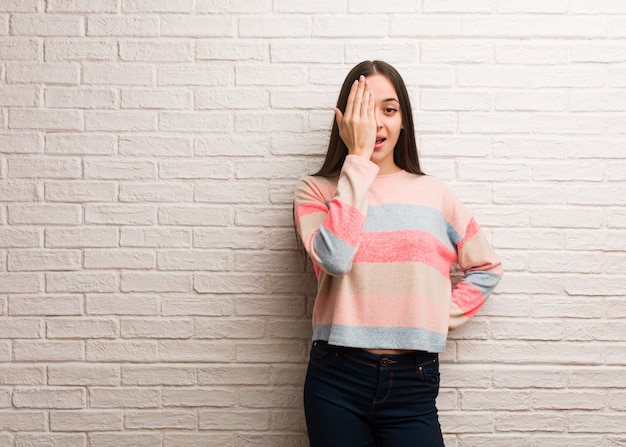 Young modern woman shouting happy and covering face with hand