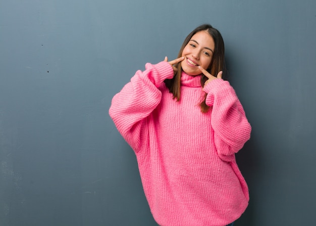 Young modern woman smiles, pointing mouth