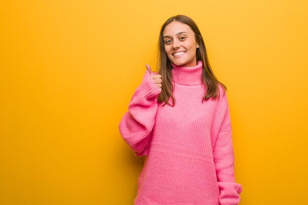 Young modern woman smiling and raising thumb up