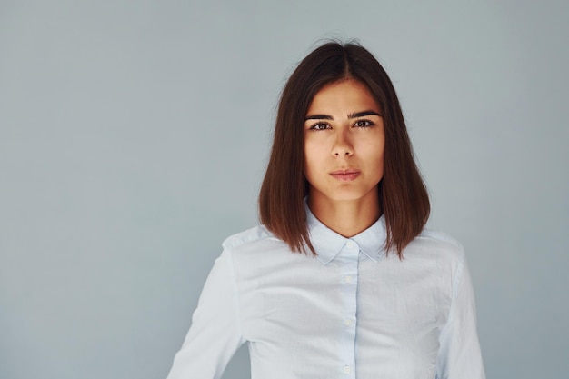 Young modern woman in white shirt standing inside of the studio