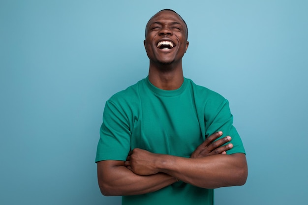 Young modest american guy dressed in a basic tshirt against the background with copy space