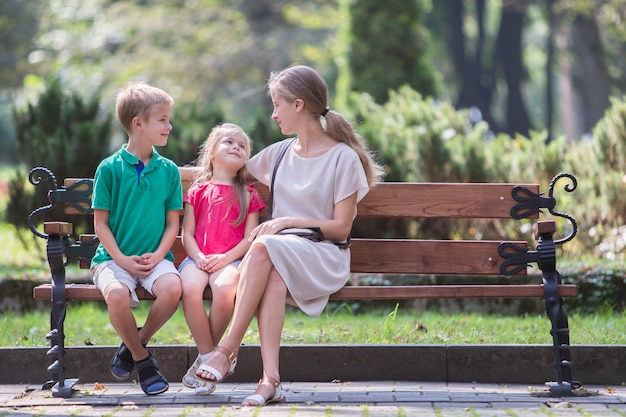 Giovane mamma e suo figlio e figlia insieme all'aperto.