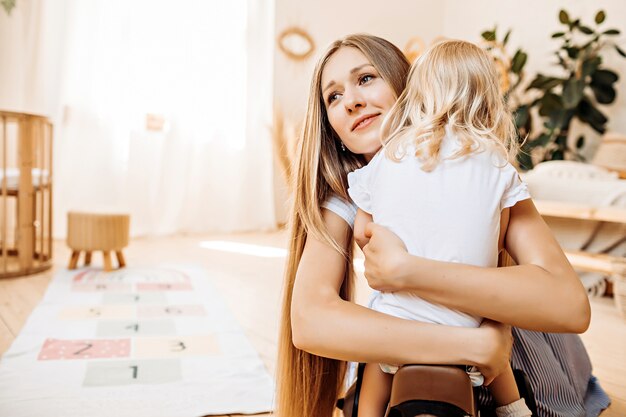 Young mom hugging her little daughter