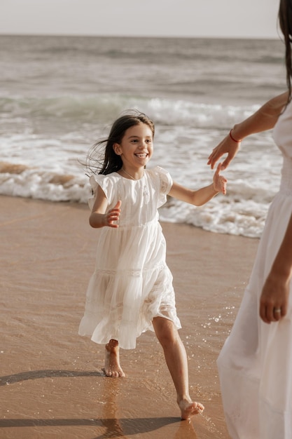 Foto giovane madre che bacia la fronte della figlia in mare