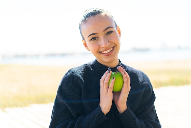 사진 야외에서 사과 들고 젊은 모로코 소녀
