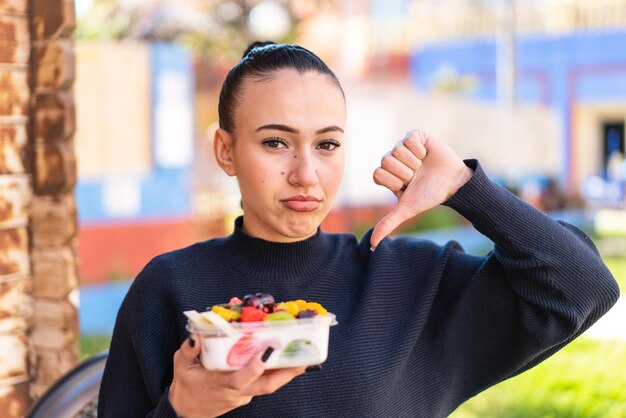 Young moroccan girl holding a bowl of fruit at outdoors