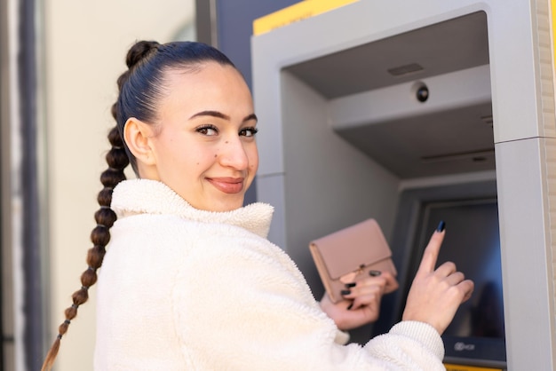 ATM を使用して屋外で若いモロッコの女の子