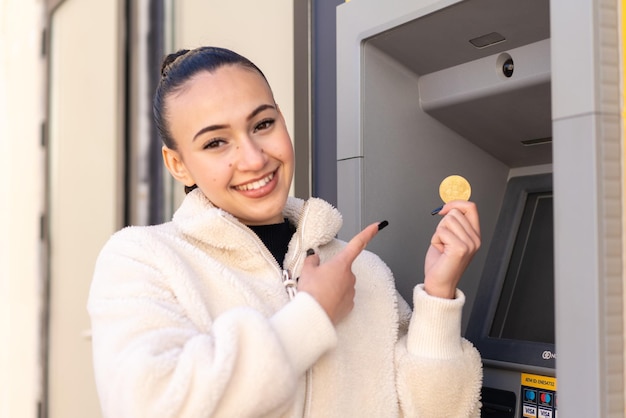 야외에서 ATM을 사용하는 젊은 모로코 소녀