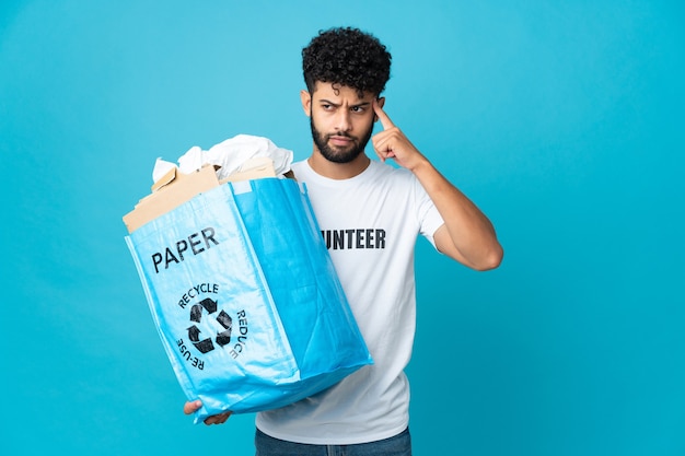 Young Moroccan man holding a recycling bag full of paper to recycle isolated