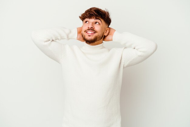 Foto giovane uomo marocchino isolato su bianco fiducioso, con le mani dietro la testa.