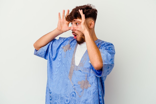 Young Moroccan man isolated on white keeping eyes opened to find a success opportunity.