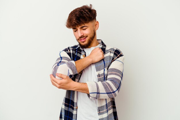 Young Moroccan man isolated on white massaging elbow, suffering after a bad movement.