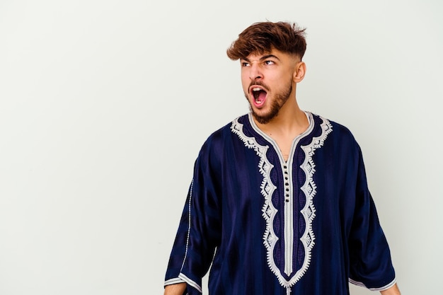 Young Moroccan man isolated on white shouting very angry, rage concept, frustrated.