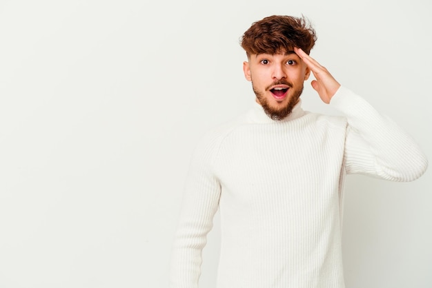 Young Moroccan man isolated on white shouts loud, keeps eyes opened and hands tense.