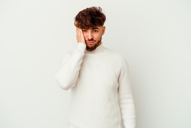 Young Moroccan man isolated on white tired and very sleepy keeping hand on head.