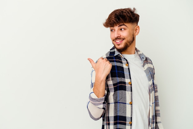 Young Moroccan man   points with thumb finger away, laughing and carefree.