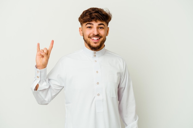 혁명 개념으로 뿔 제스처를 보여주는 흰색 절연 전형적인 아랍 옷을 입고 젊은 모로코 남자.