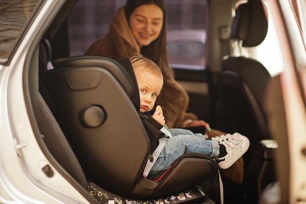 写真 車の中で若い母と子椅子のベビーシート安全運転の概念