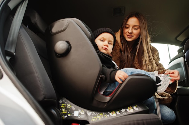 Young mother and child in car Baby seat on chair Safety driving concept