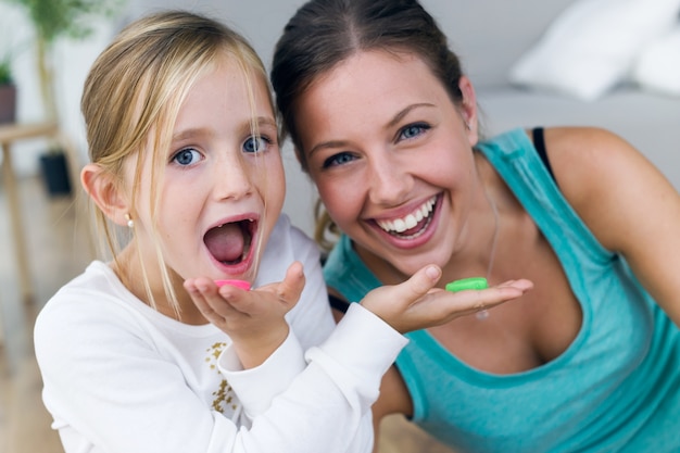 Photo young mother and daughter eating sweets at home.