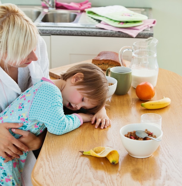 Young mother and daughter having breakfast