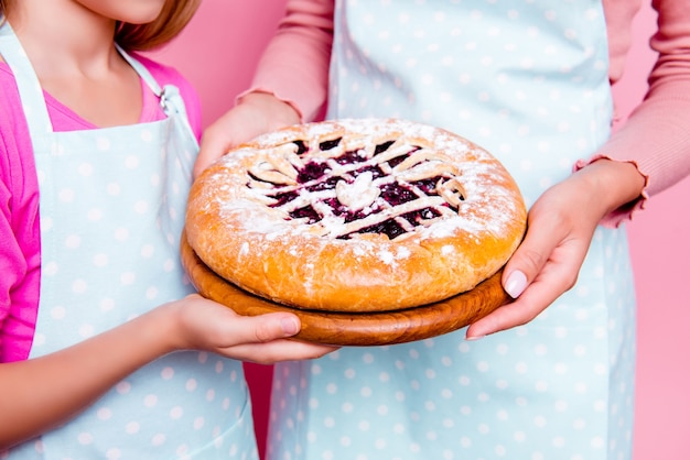 ケーキを保持している若い母と娘