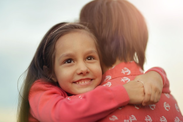 Young mother and daughter hugging in park